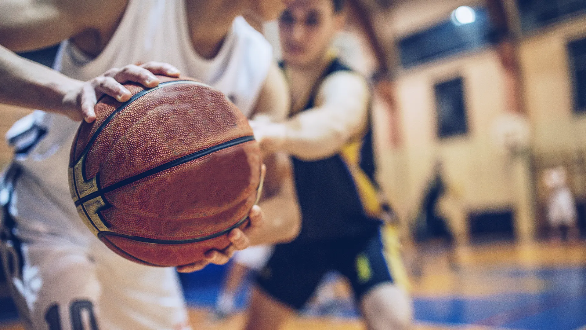 Two basketball players competing for the basketball.